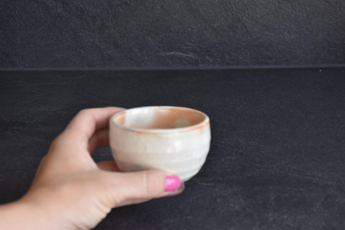 Set of 5 white kumidashi teacups size next to a hand