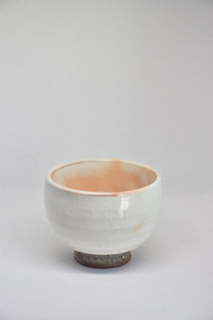 Set Of 5 White Kumidashi Teacups single cup front profile resting on its unglazed dark clay base foot