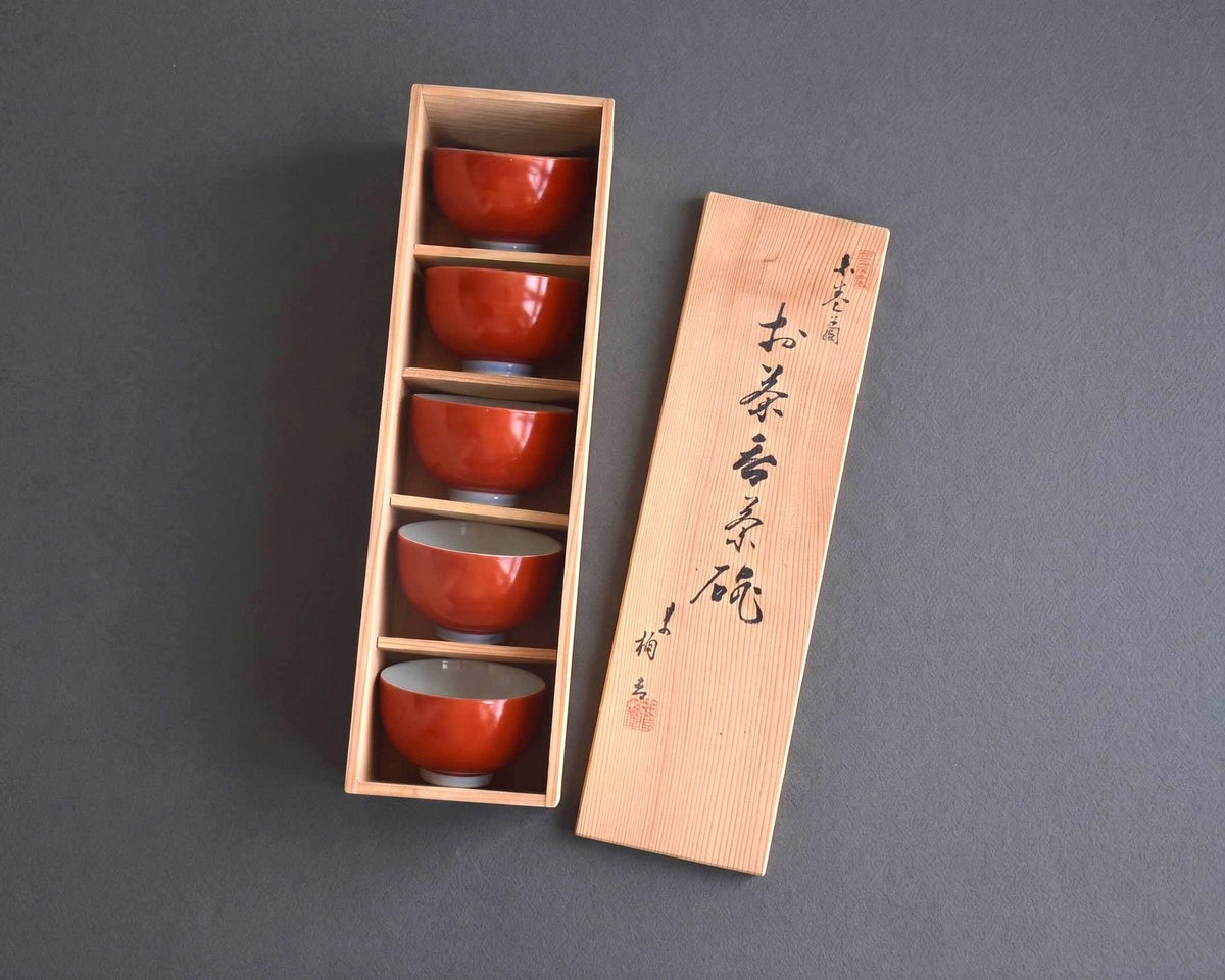 Koransha tea cup set with all five vermilion bowls neatly stacked inside the open wooden box