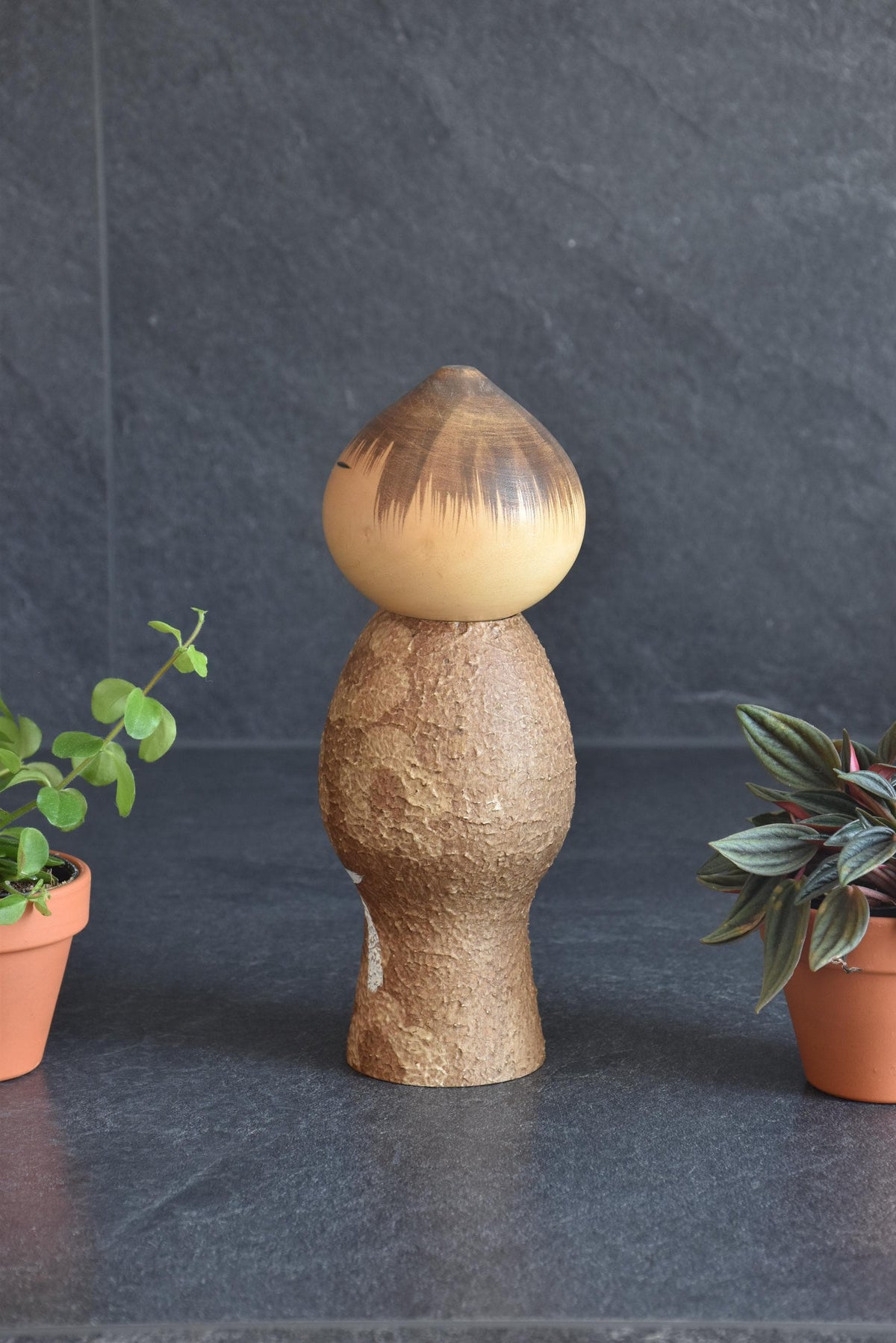Masao Watanabe Sosaku Kokeshi Doll Mushin shown from the back against a dark textured background