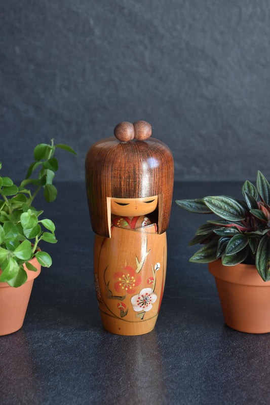 Sosaku Kokeshi Doll By Kojo Tanaka Ume Blossoms standing between small potted plants