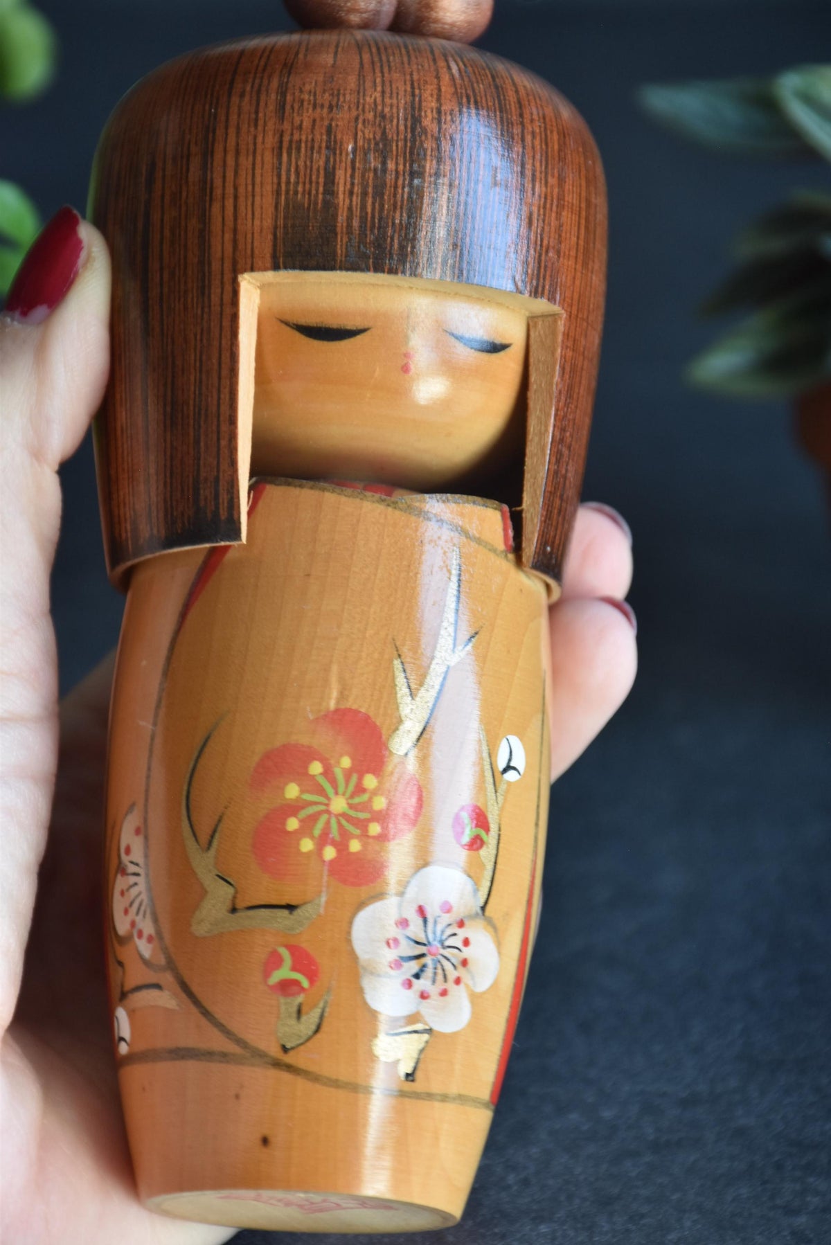Kojo Tanaka Sosaku Kokeshi doll held in a hand to show scale and full front view