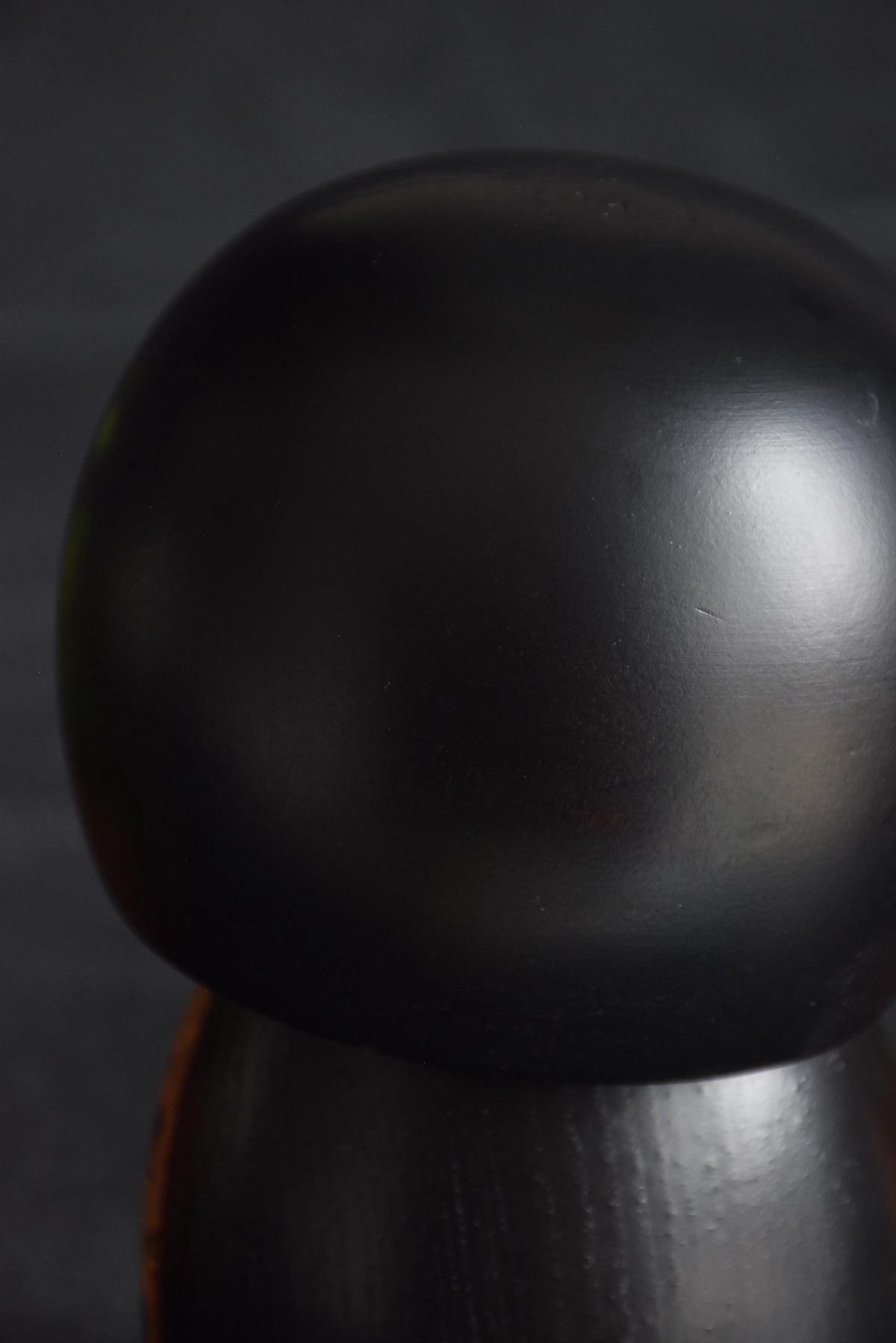 Kazuo Takamizawa kokeshi head top showing the black finish and carved hair lines