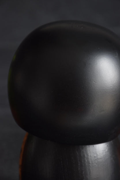 Kazuo Takamizawa kokeshi head top showing the black finish and carved hair lines