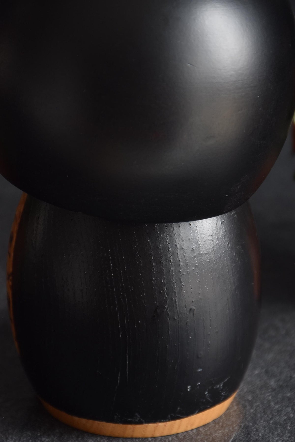 Kazuo Takamizawa kokeshi lower body showing the textured black wooden finish