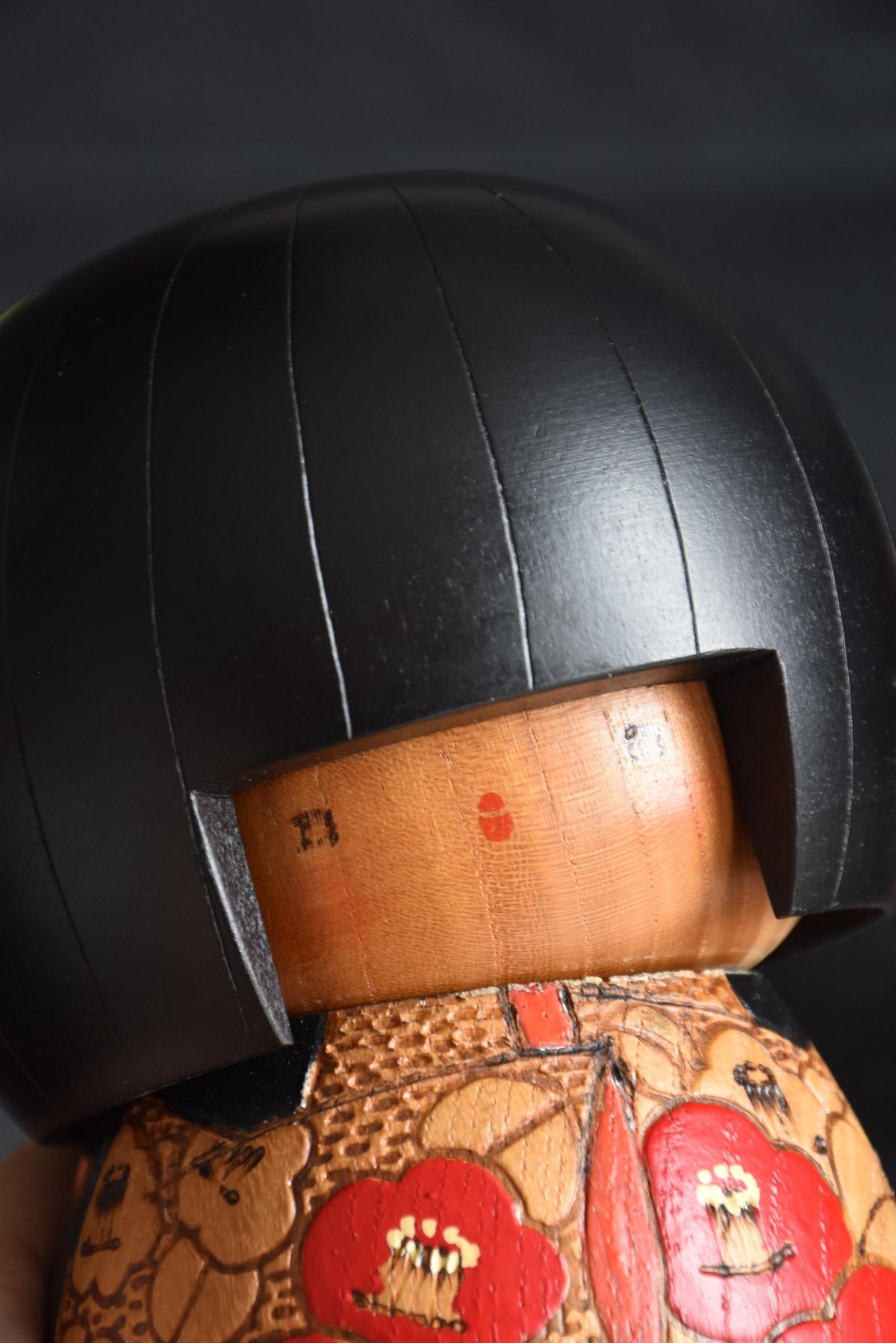 Kazuo Takamizawa kokeshi face angle close-up showing the minimalist features and wood grain