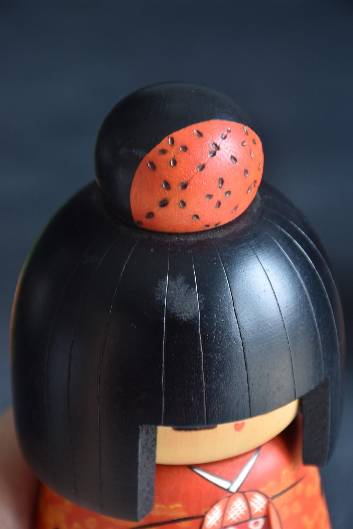 Kazuo Takamizawa kokeshi doll close-up of the hair topknot, highlighting texture and painted patterns