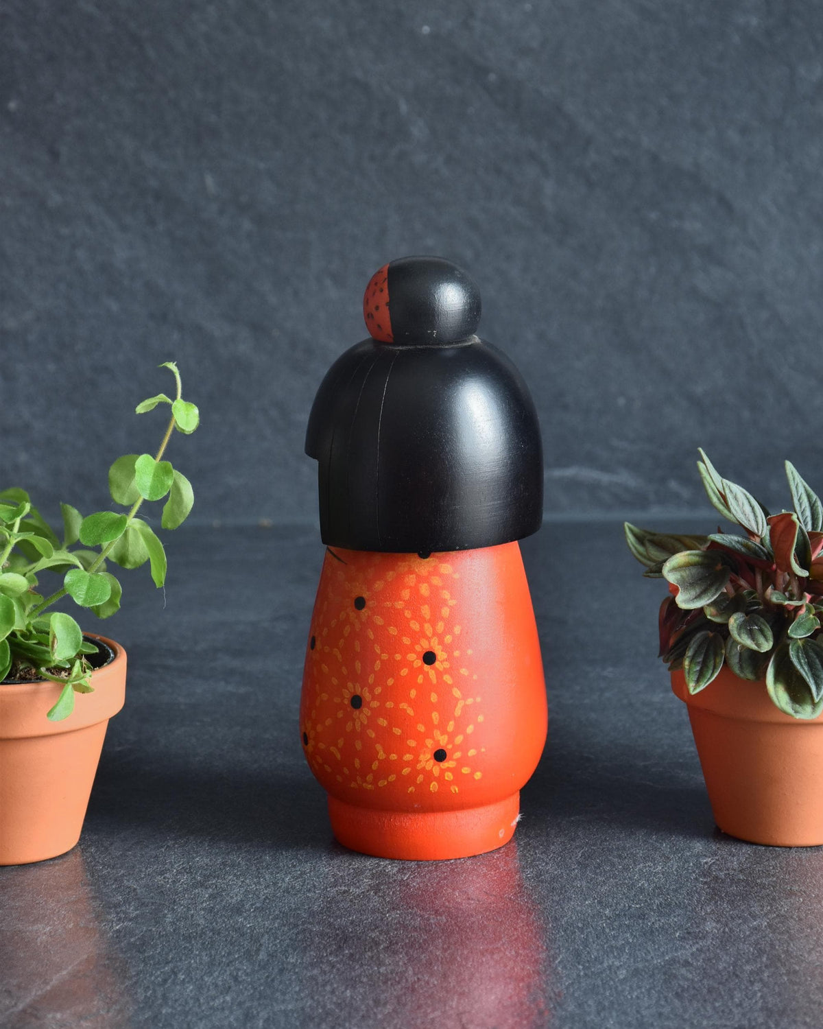 Kazuo Takamizawa kokeshi doll shown from the back, highlighting the smooth black bob haircut