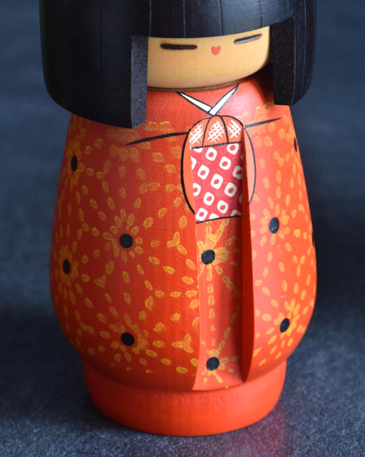 Kazuo Takamizawa kokeshi doll close-up of the front, detailing the painted face and carved inner kimono