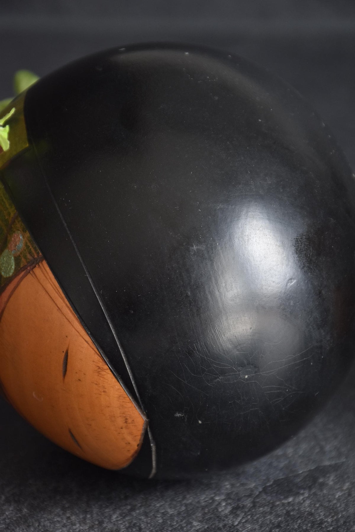 Toa Sekiguchi Sosaku Kokeshi Doll close-up of the smooth black wooden back showing minor scratches