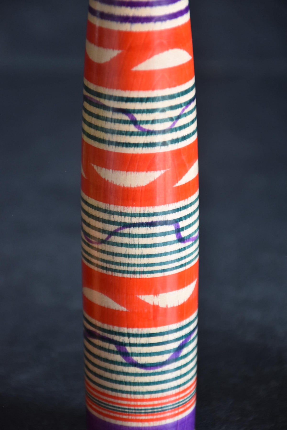 Tsuchiyu kokeshi doll body detail showcasing red green and purple rokuro-moyo rings