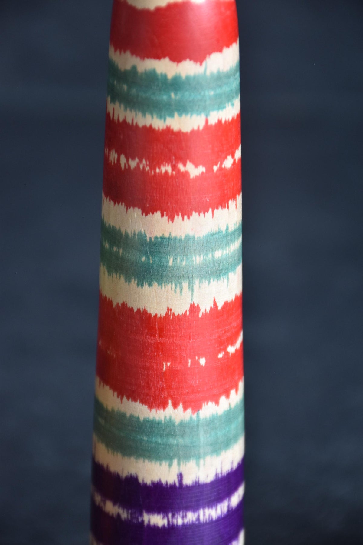 Tsuchiyu-Kei kokeshi body detail showing red, green, and purple lathe-spun bands