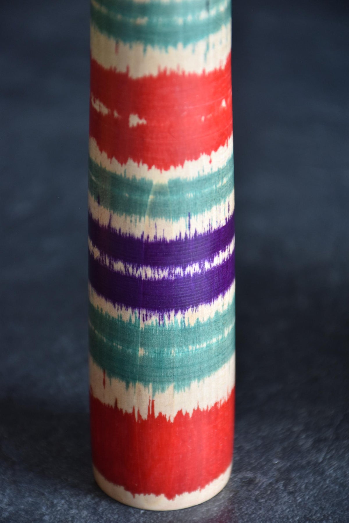Tsuchiyu-Kei kokeshi lower body section featuring purple and green horizontal painted stripes