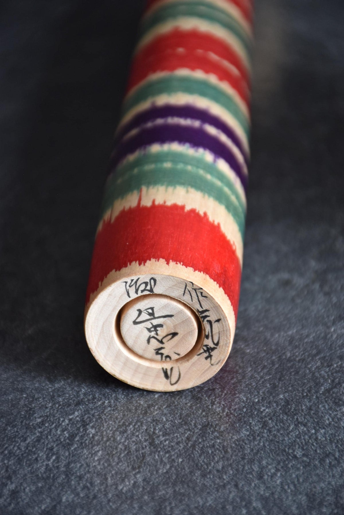 Tsuchiyu-Kei kokeshi base showing handwritten artisan signature and natural wood grain