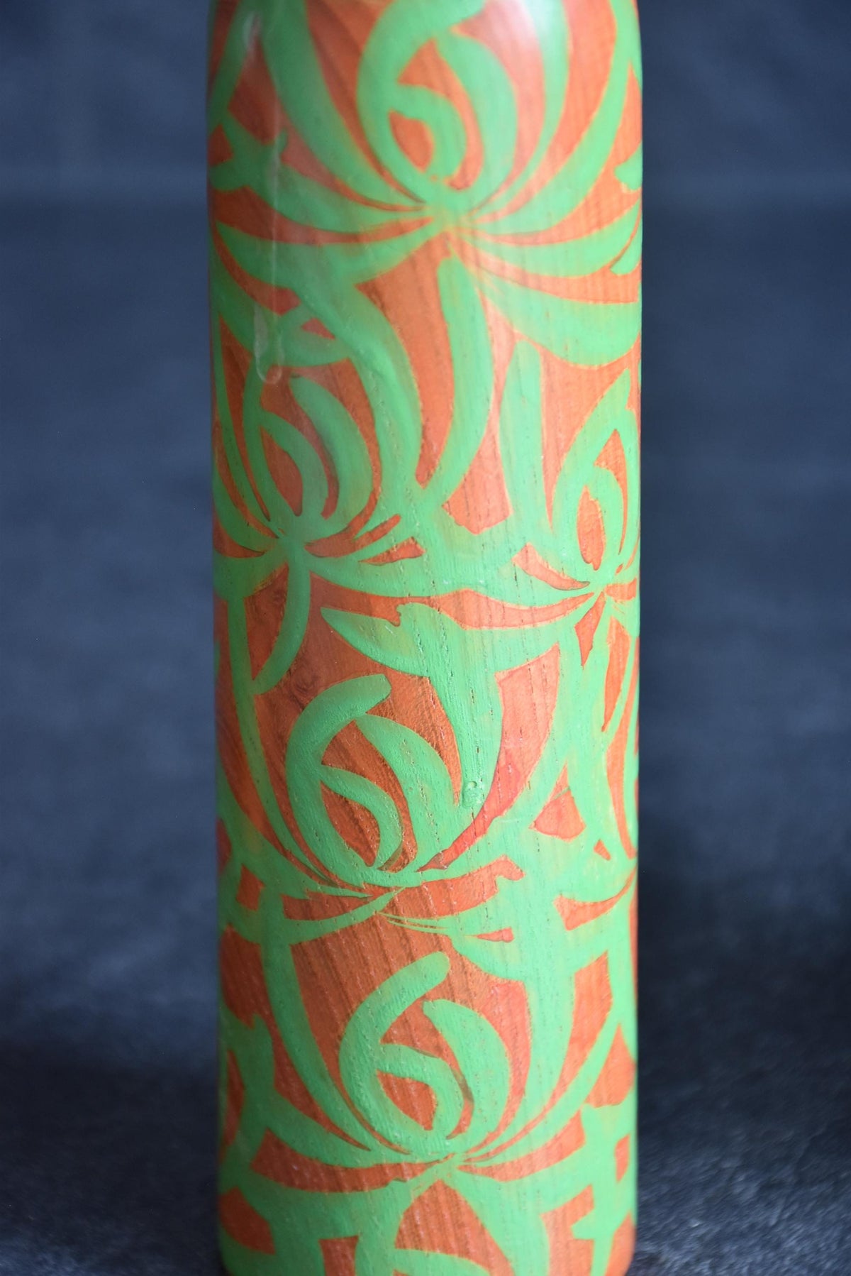 Issetsu Kuribayashi sosaku kokeshi doll showing body covered in vibrant green floral motif