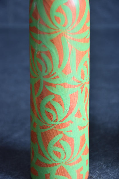 Issetsu Kuribayashi sosaku kokeshi doll showing body covered in vibrant green floral motif