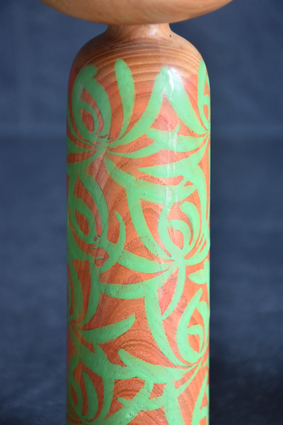 Issetsu Kuribayashi sosaku kokeshi doll showing upper body and green arabesque pattern