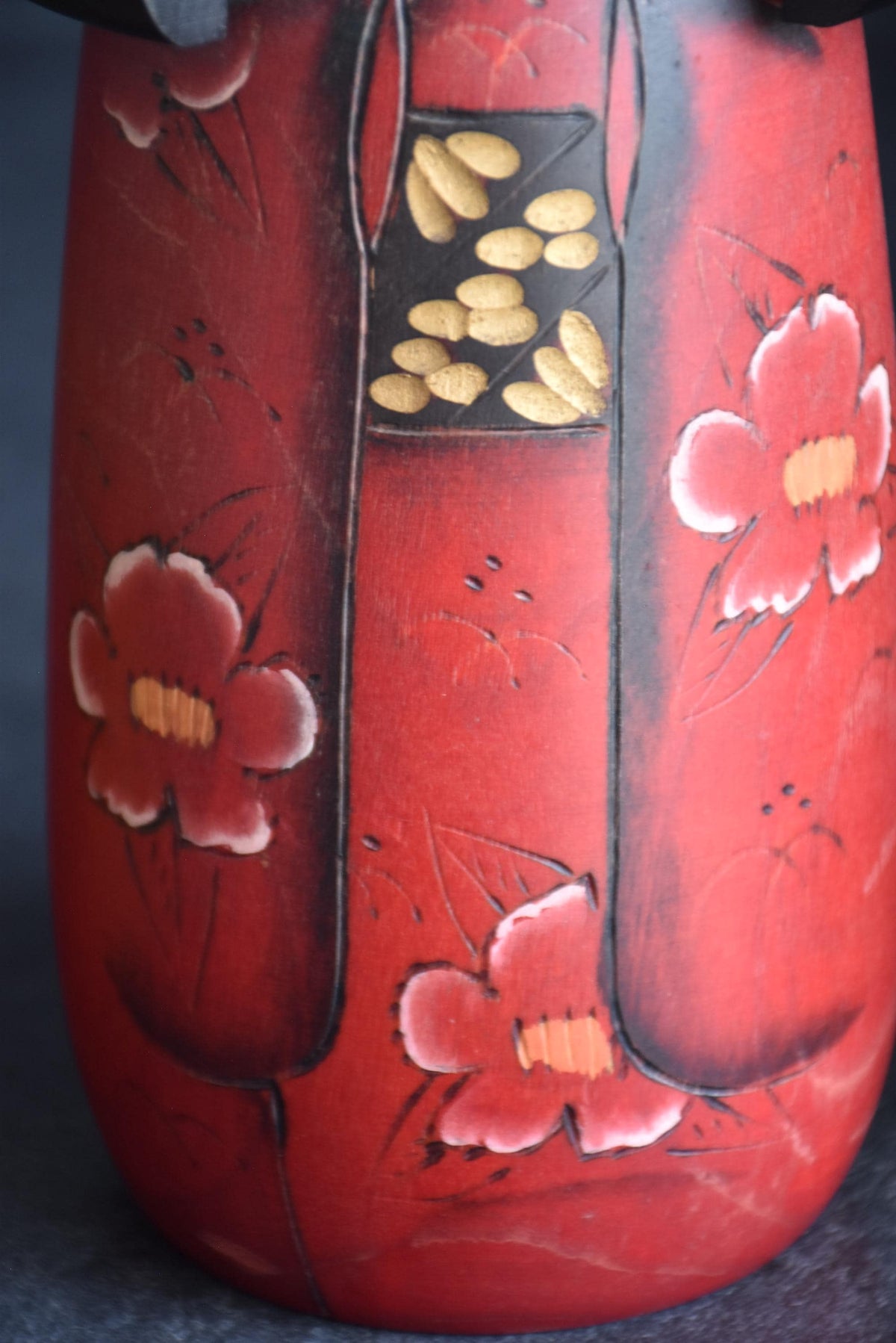 Masae Fujikawa kokeshi doll pattern detail showing the hand-decorated carved camellia motifs