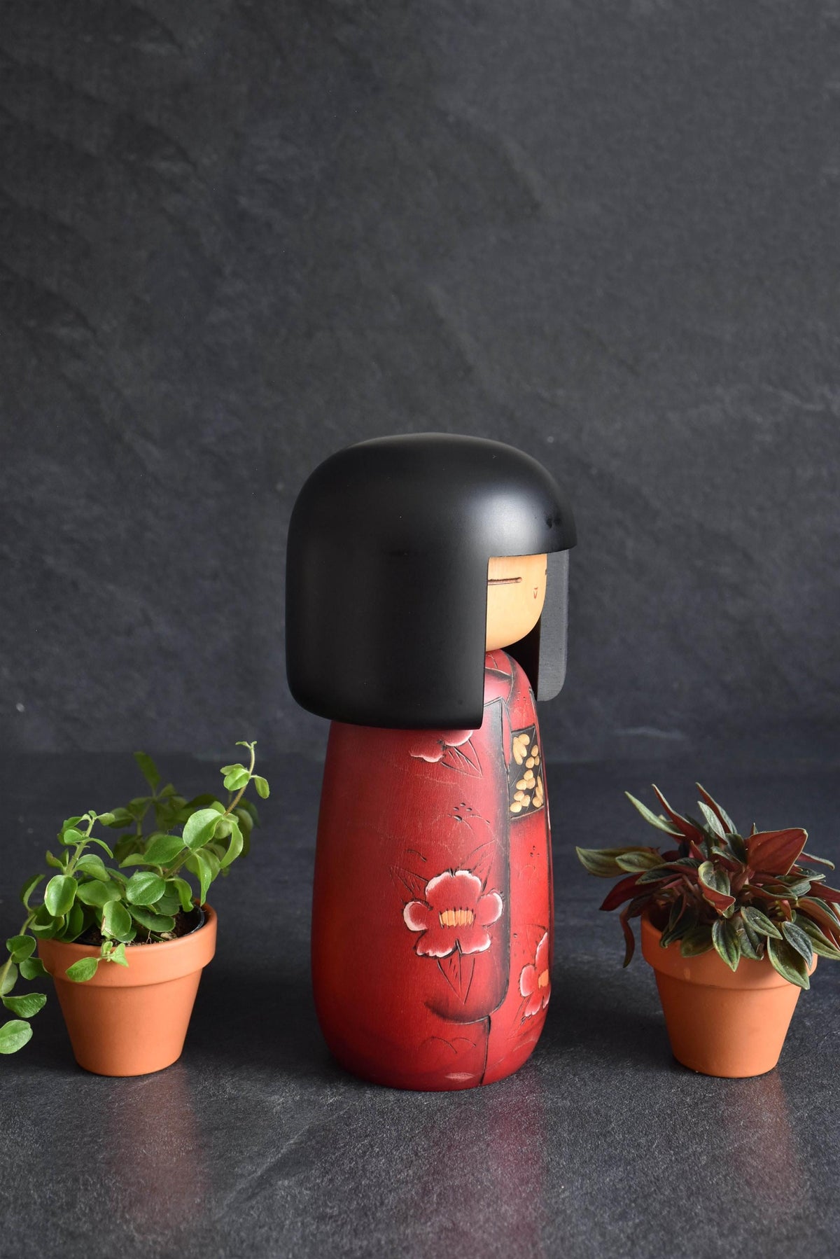 Masae Fujikawa kokeshi doll three-quarter view highlighting the side of the red kimono