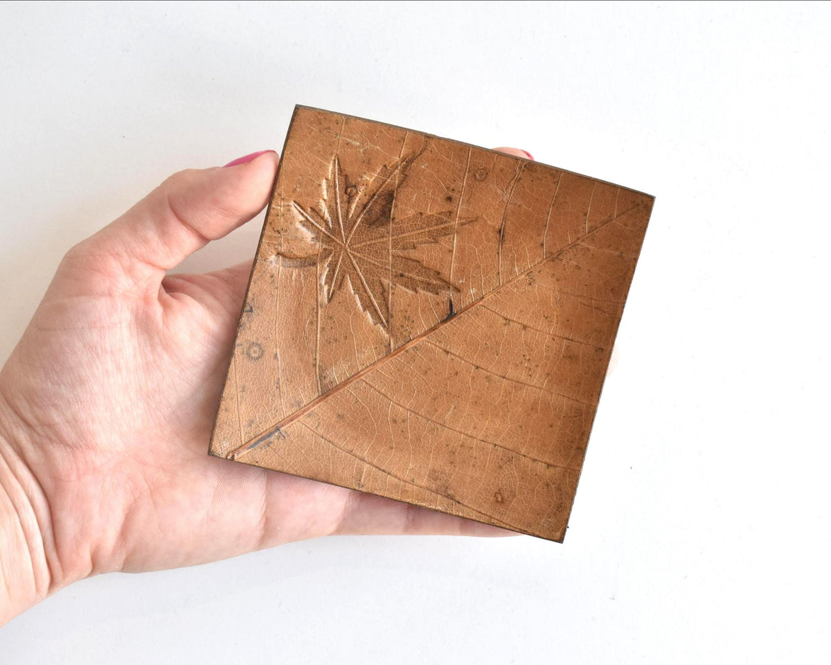 Hida Kōgei Hōba Magnolia Leaf Tray shown next to a hand for scale
