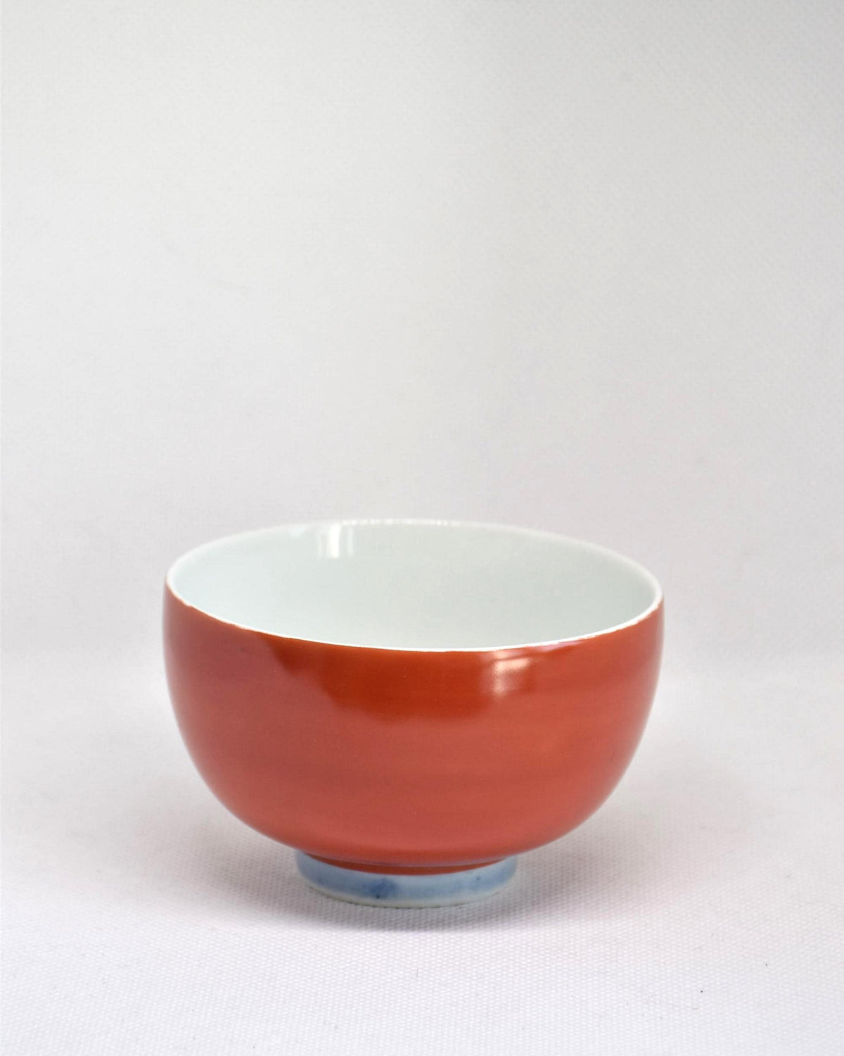 Koransha tea cup set featuring a single red porcelain bowl with minor glaze pops and pinholes