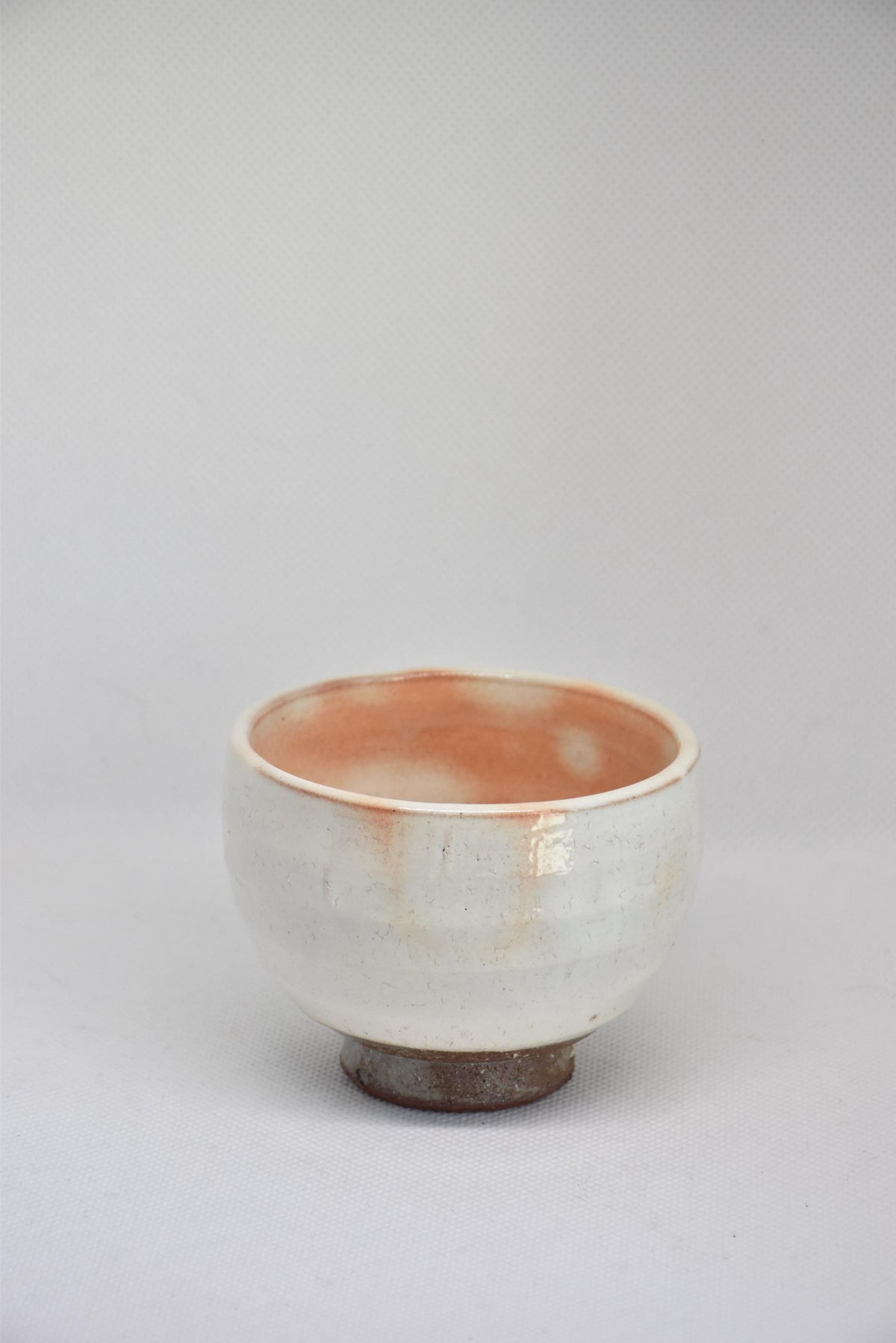 Set Of 5 White Kumidashi Teacups single cup angled view showing the earthy dark foot and white ceramic glaze