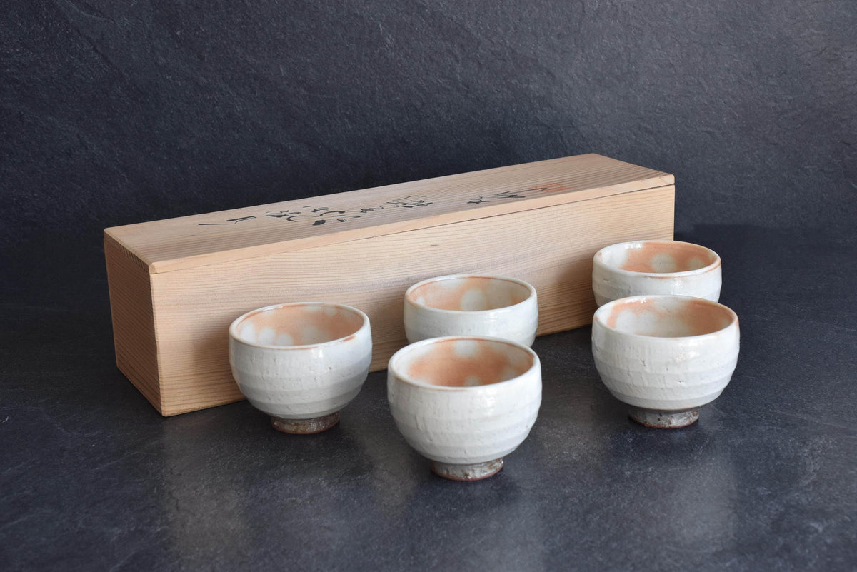 Set Of 5 White Kumidashi Teacups displayed in front of the inscribed paulownia wood tomobako box