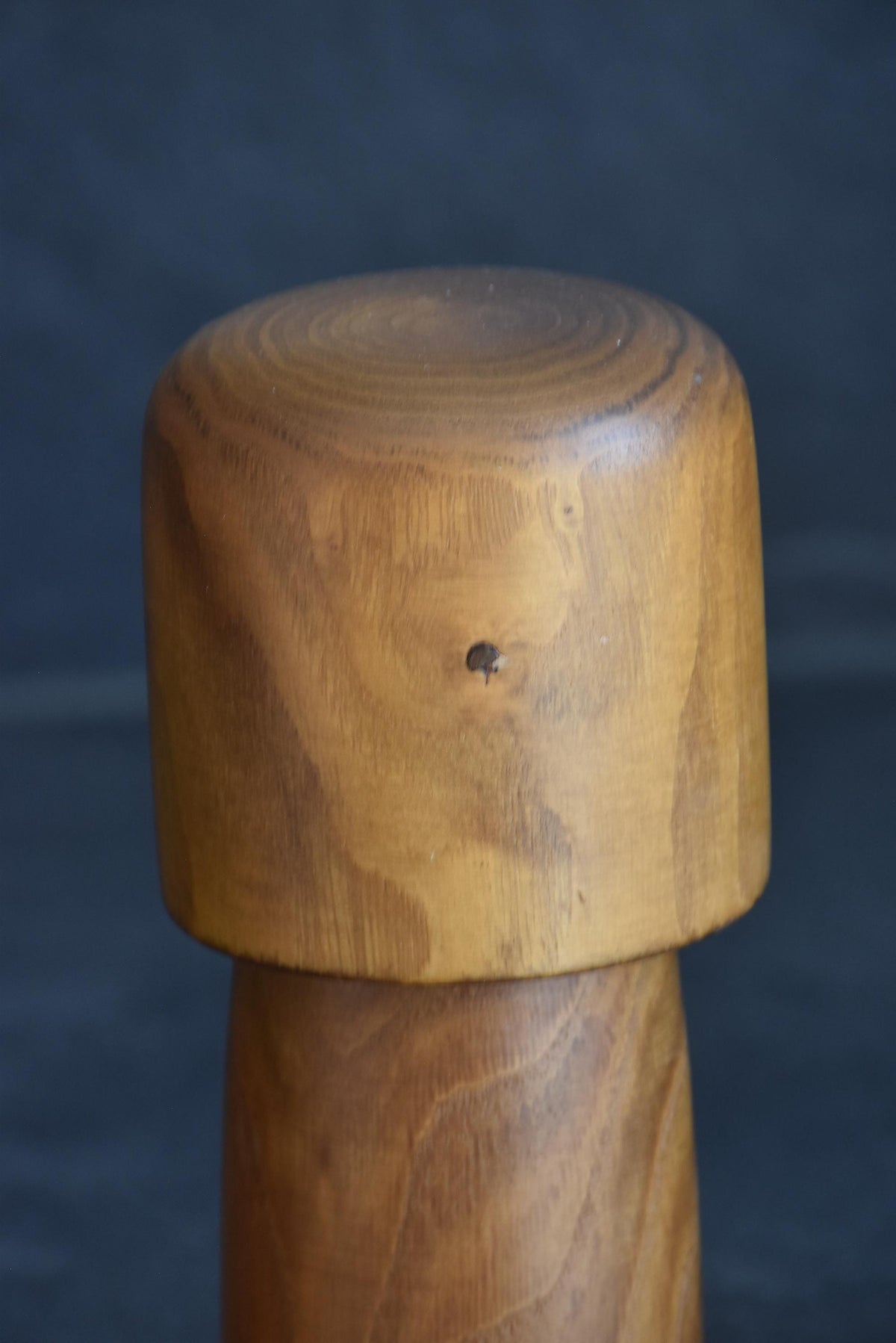 Usaburo kokeshi doll head detail showing the smooth rounded top and wood knot