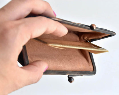 Blue Oshima Tsumugi Silk Gamaguchi Coin Purse held open in a hand showing the spacious interior lining.