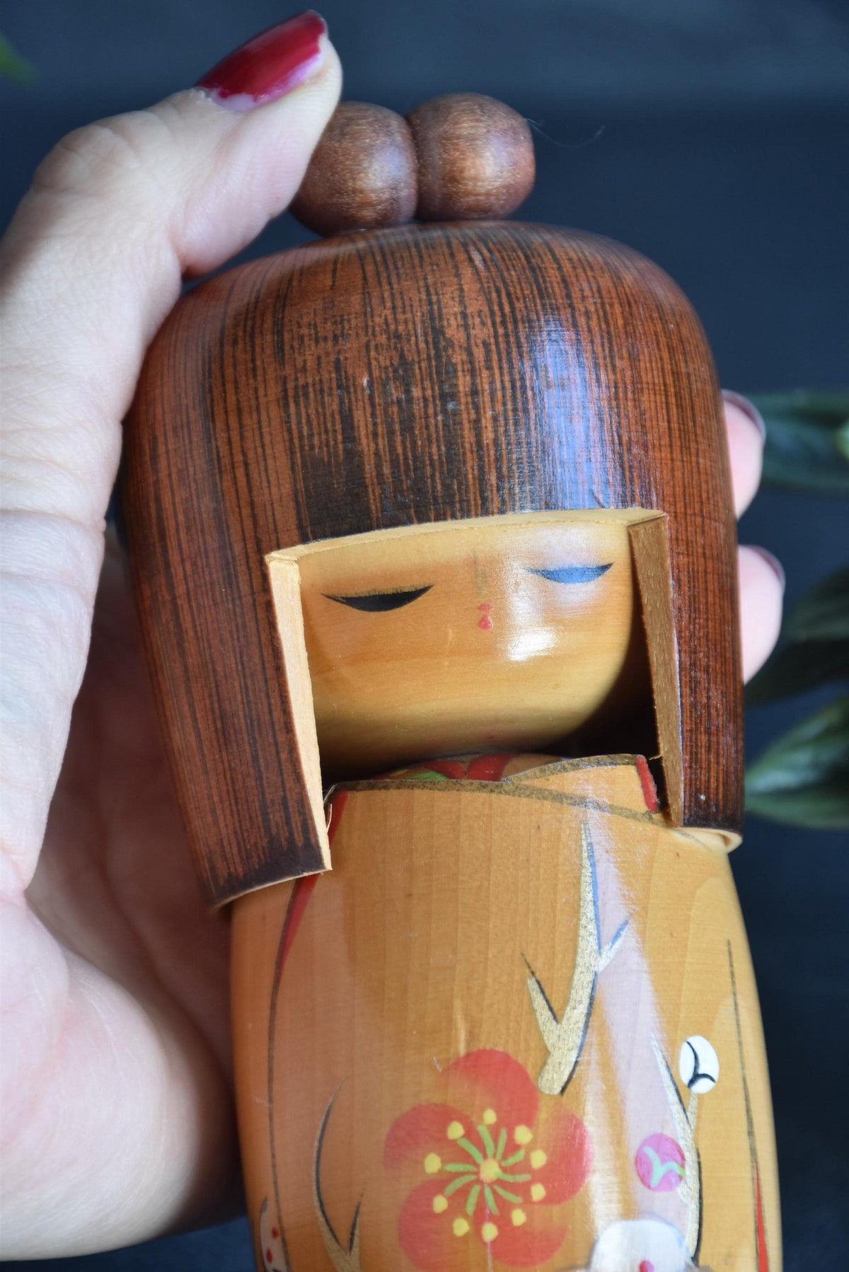 Kojo Tanaka Sosaku Kokeshi doll close up of the face held in a hand