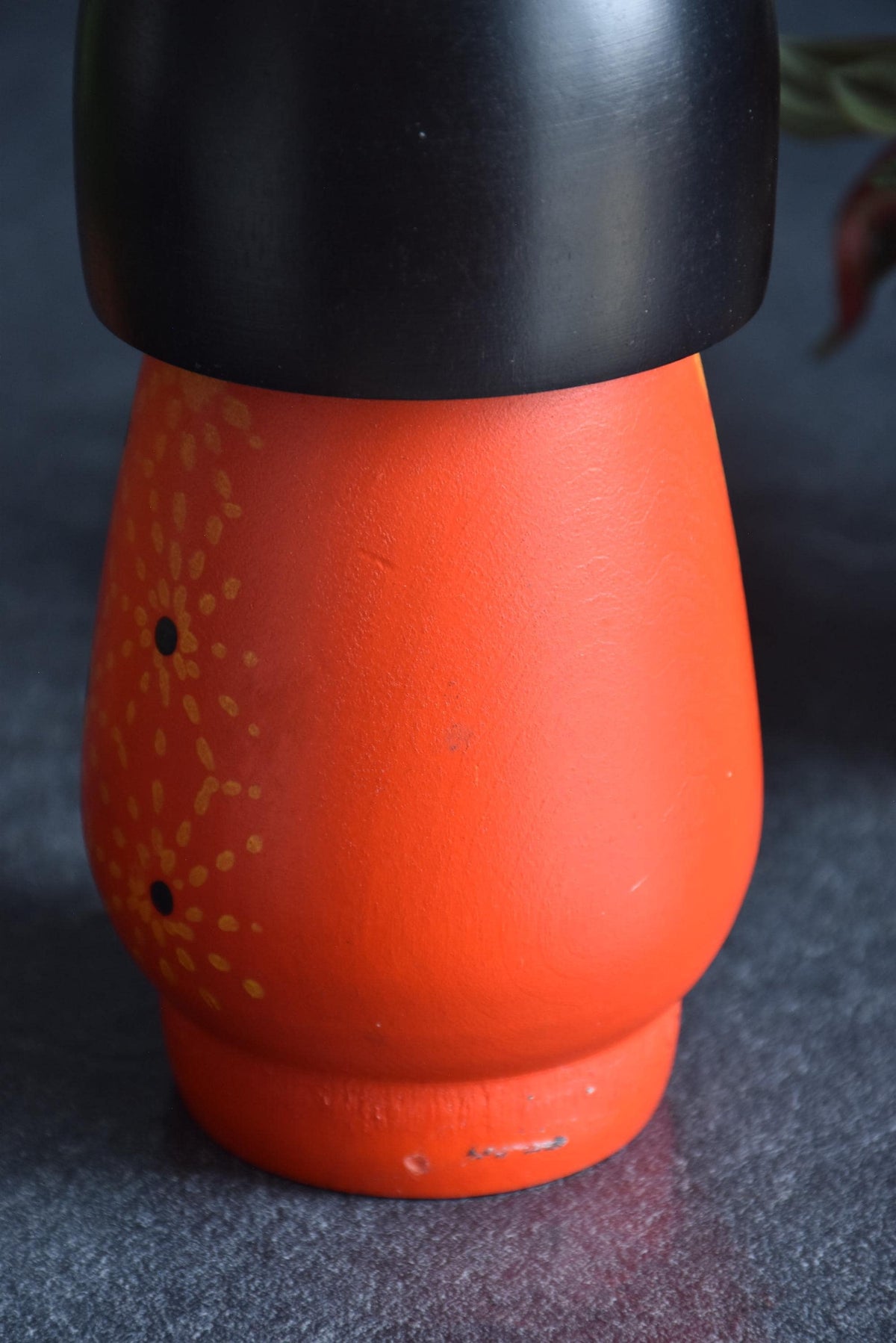 Kazuo Takamizawa kokeshi doll body detail, showing vintage texture and orange painted flower motifs