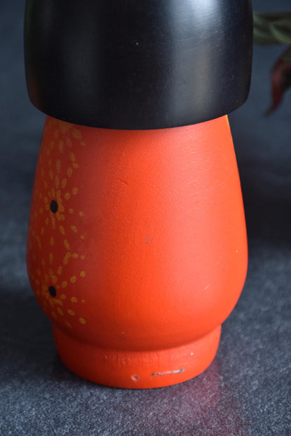 Kazuo Takamizawa kokeshi doll body detail, showing vintage texture and orange painted flower motifs