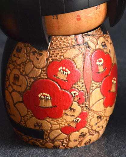 Kazuo Takamizawa kokeshi kimono detail showing the red and orange incised camellia flowers
