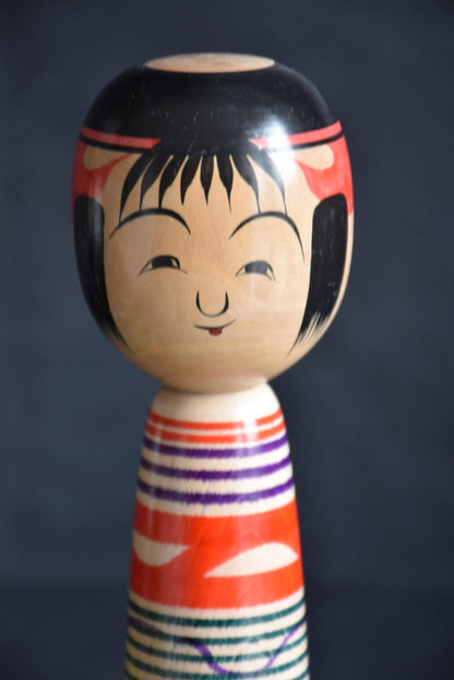 Tsuchiyu kokeshi doll close-up of the hand-painted smiling face with hair and headband