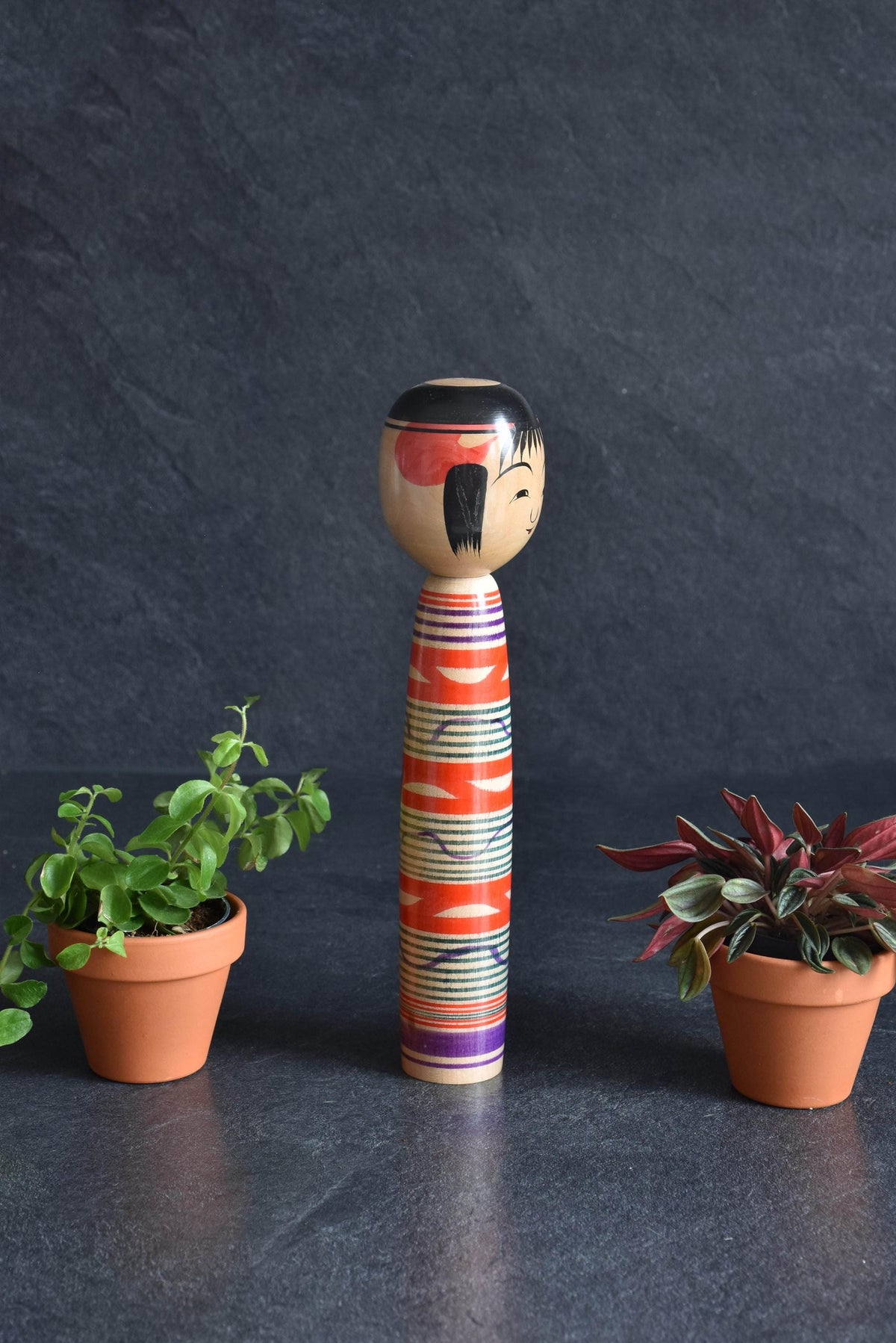 Tsuchiyu kokeshi doll viewed from another angle showing painted hair and wooden grain