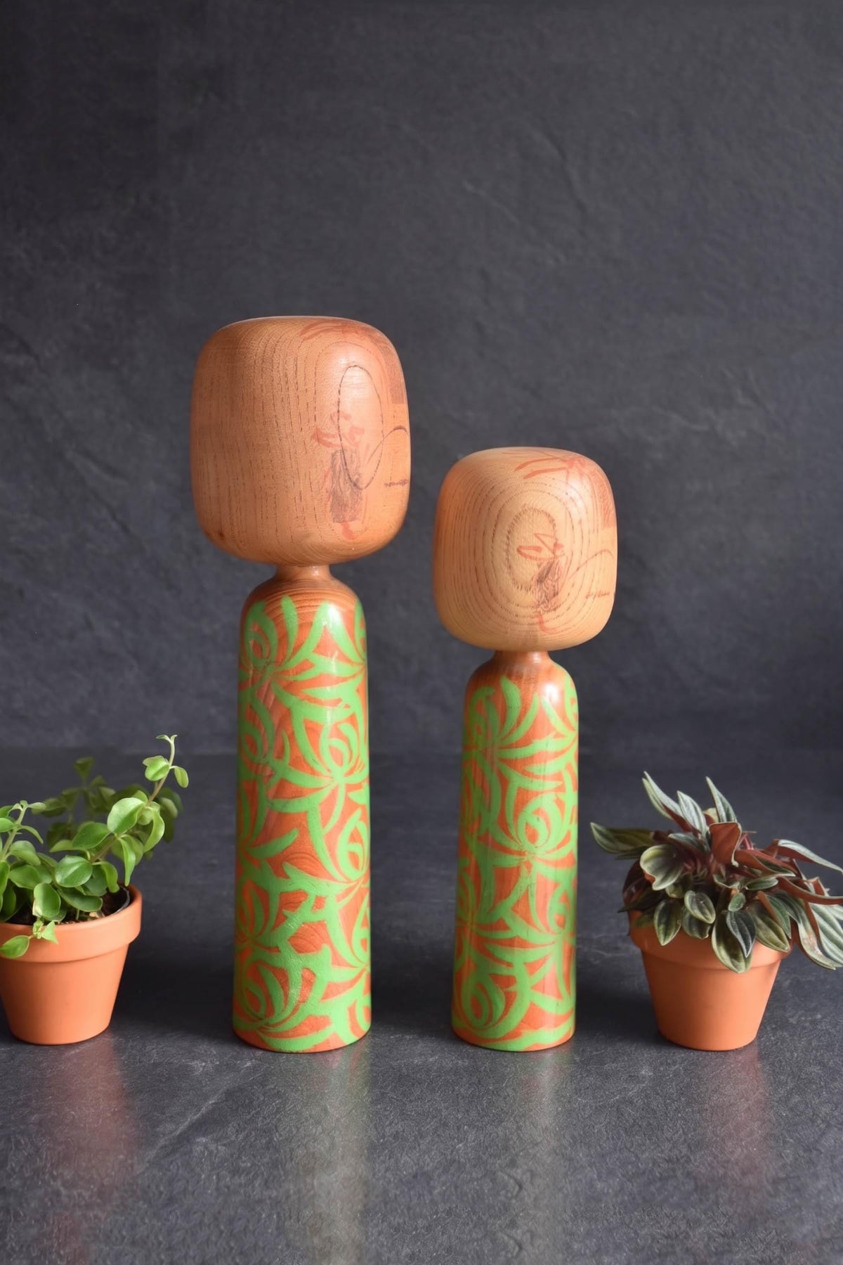 Issetsu Kuribayashi sosaku kokeshi pair showing natural wood grain texture on the heads