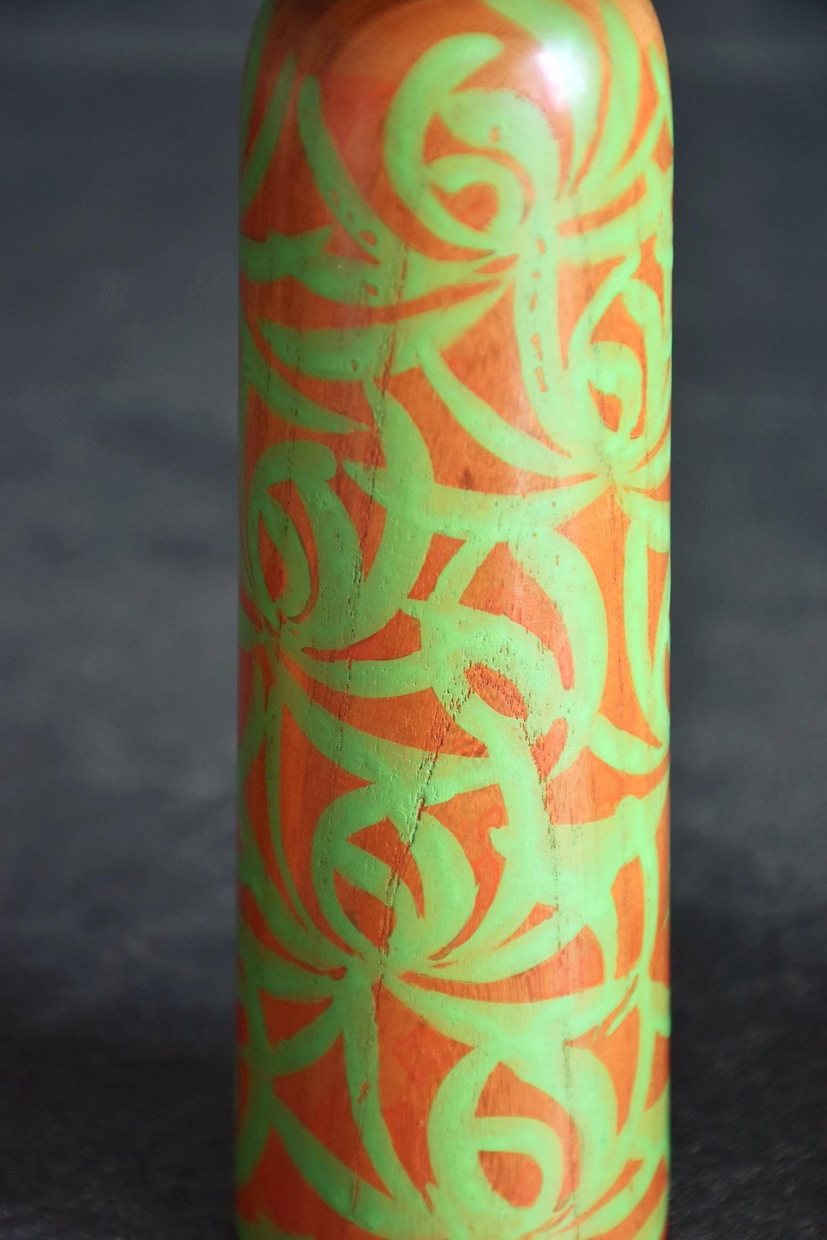 Issetsu Kuribayashi sosaku kokeshi doll showing green hand painted arabesque pattern detail