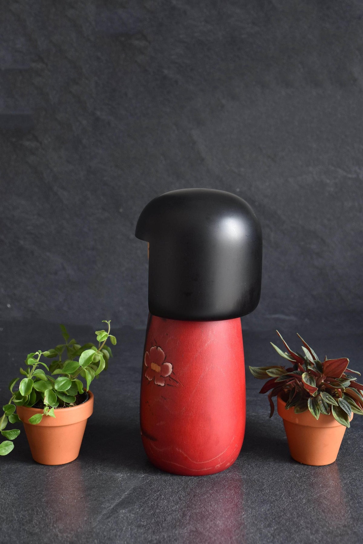 Masae Fujikawa kokeshi doll angled view showing the smooth matte black bob and minimalist face details