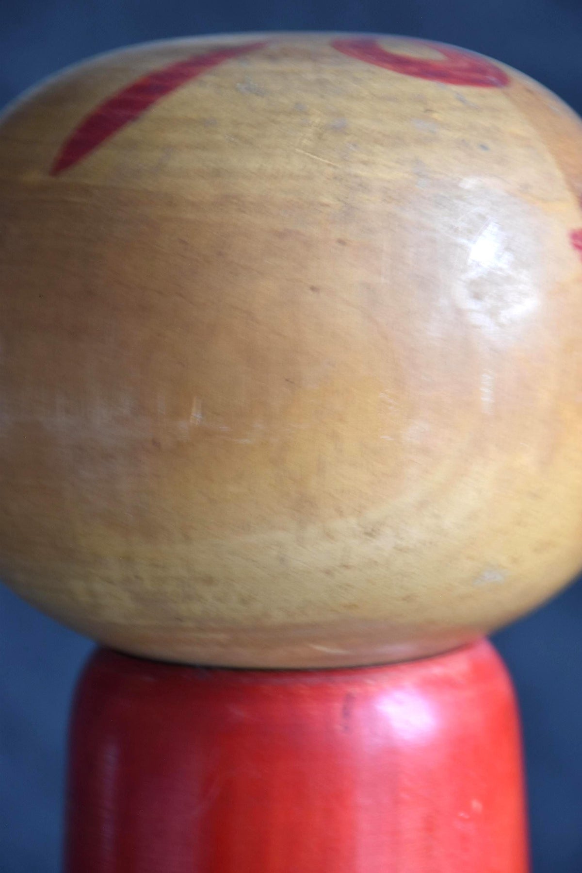 Hakuho Sosaku Kokeshi doll head detail showing the smooth wooden sphere and natural wood grain texture.