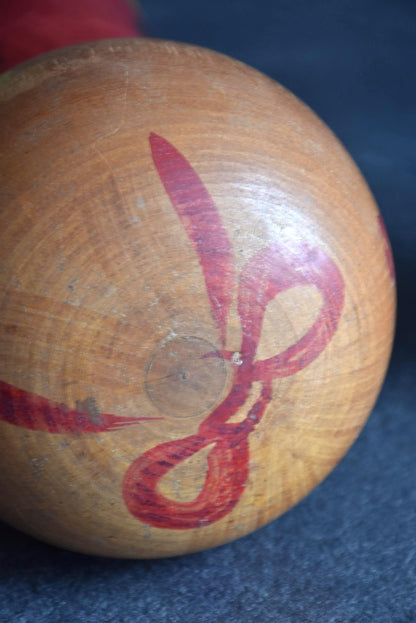 Hakuho Sosaku Kokeshi doll top of head view showing the red painted hair ornament pattern and wood grain.