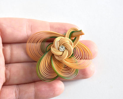 Hand-Woven Bamboo Knot Brooch In Beige And Green held in an open hand