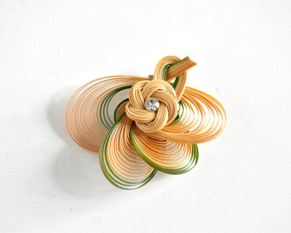 Hand-Woven Bamboo Knot Brooch In Beige And Green on a plain white surface