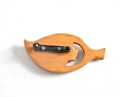 Ainu hand-carved wooden brooch back showing the smooth flat reverse