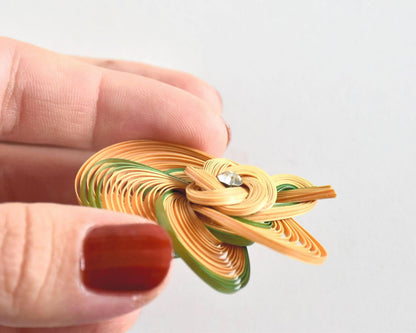 Hand-Woven Bamboo Knot Brooch In Beige And Green angled view held in hand