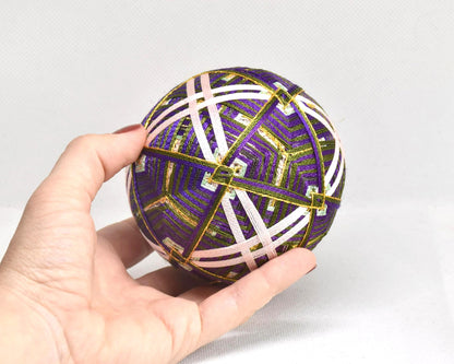 Hand-Embroidered Japanese Temari Ball Folk Art held in a hand for scale, measuring approximately 9 cm