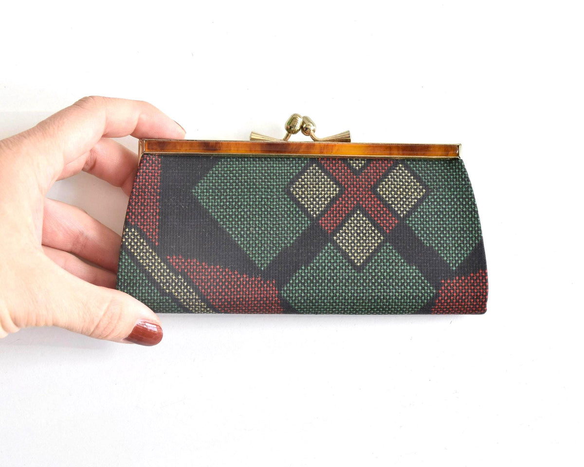 Green Oshima Tsumugi Silk Gamaguchi Coin Purse held in hand to demonstrate scale.