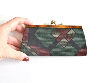 Green Oshima Tsumugi Silk Gamaguchi Coin Purse held in hand to demonstrate scale.