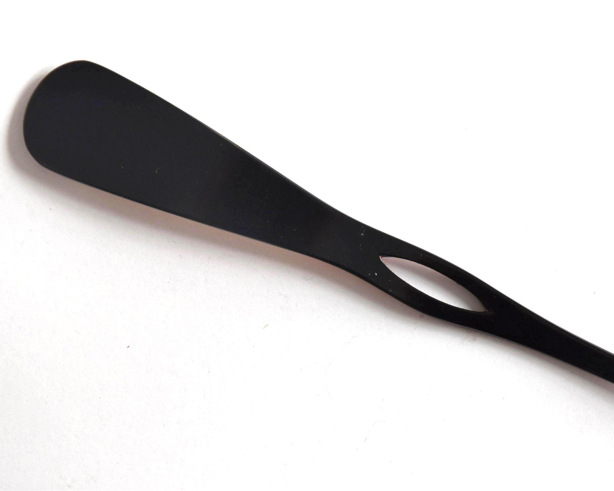 Red lacquered kanzashi hair accessory showing the black back of the paddle