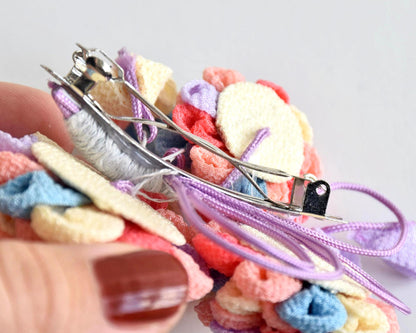 Chirimen Crepe Tsumami-Zaiku Floral Kanzashi Barette held in hand to display scale and clasp
