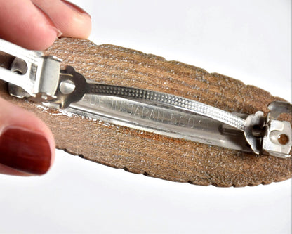 Ainu wooden hair barrette back view showing the Made in Japan stamp on the metal clip